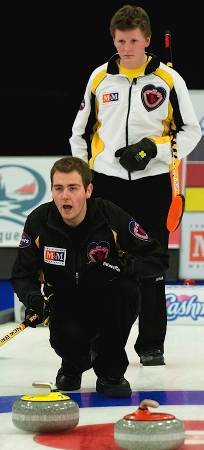 New Brunswick skip René Comeau, front, calls instructions to his sweepers as Manitoba skip Braden Calvert looks on. (Photo, CCA/Michael Burns Photography/Mark O'Neill)