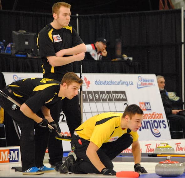 Manitoba third Kyle Kurz, right, calls sweeping instructions to his teammates as New Brunswick skip Rene Comeau, top, and third Andrew Burgess look on. (Photo, Amanda Rumboldt)