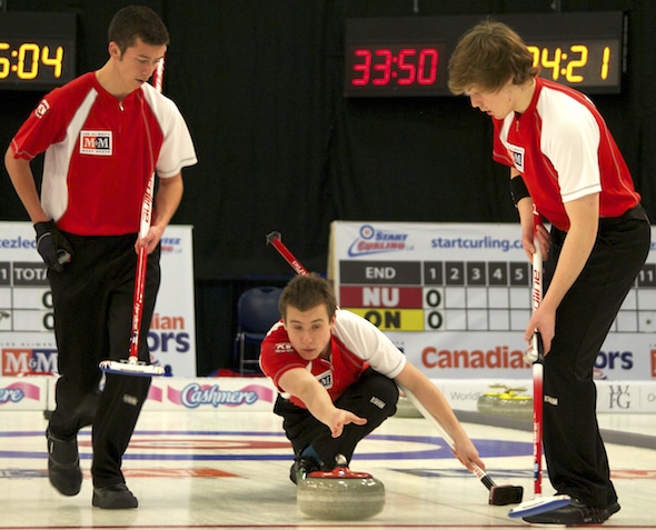 Newfoundland/Labrador skip Greg Smith delivers rock to sweepers Kyle Barron, left, and Ryan McNeil Lamswood. (Photo, Amanda Rumboldt)