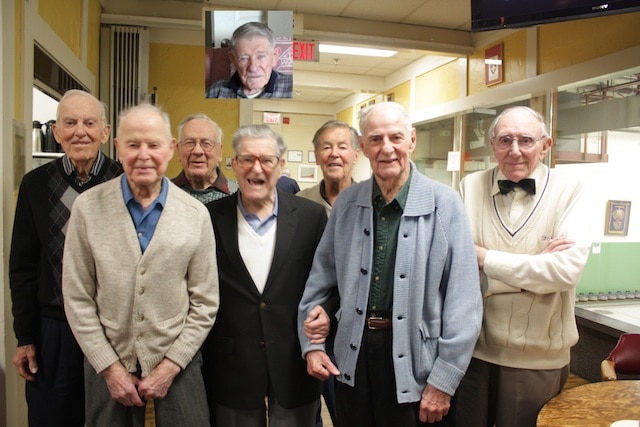 Les nonagénaires des Tam Heather Venerables ont été mis à l’honneur à la fin de la saison 2013-2014 (de gauche à droite): Monte Miller (92), Bob McCowan, (96), Bill Wood (90), Ross Ellis (90), Gord Ramsay (90), Morley Lumby (94), Alex Smith (90), et un membre absent, récemment blessé dans une chute, mais présent dans les cœurs de tous : Bill Reid (photo en médaillon, 95 ans), (photo soumise par A. Lamb)