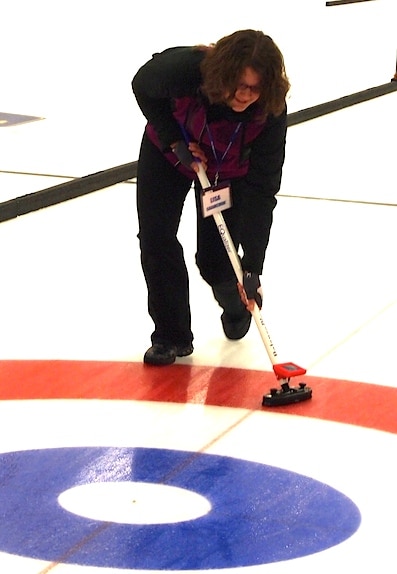 Lisa Shamchuk tries out a training broom that measures sweeping speed and pressure. (Photo by Lisa Shamchuk)