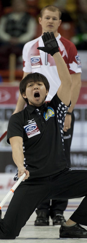 Japonaise capitaine Yusuke Morozumi crie des instructions à ses balayeuses que Carter Rycroft du Canada regarde. (Photo, Curling Canada / Michael Burns)