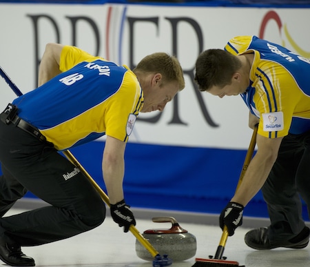 Marc Kennedy de l'Alberta, à gauche, et Ben Hebert balayer lors de leur victoire sur le Nouveau-Brunswick le vendredi. (Photo, Curling Canada / Michael Burns)