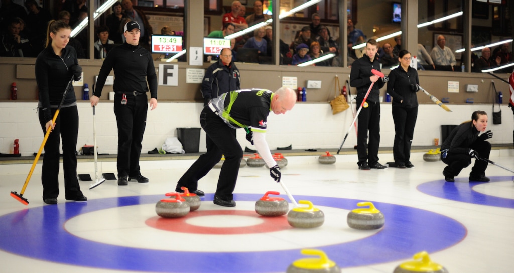 Tess Bobbie and Bowie Abbis-Mills (left) watch as Glenn Howard sweeps a rock in the house during action at the Ottawa Hunt and Golf Club (Photo Claudette Bockstael)