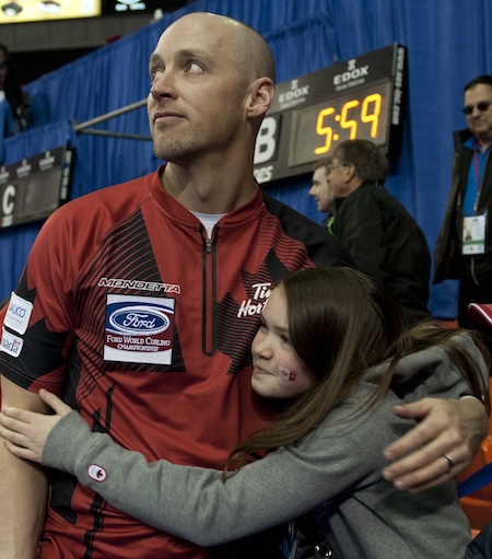 Nolan Thiessen du Canada reçoit l'accolade après-match de la fille Tyra après avoir remporté la médaille de bronze, dimanche. (Photo, Curling Canada / Michael Burns)
