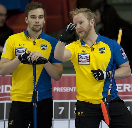 Niklas Edin de la Suède, à droite, discute des options avec son coéquipier Oskar Eriksson. (Photo, Curling Canada / Michael Burns)