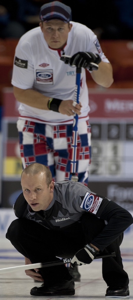 Pat Simmons d'Équipe Canada montres son tir, avec Christoffer Svae de la Norvège regardant par-dessus son épaule. (Photo, Curling Canada / Michael Burns)