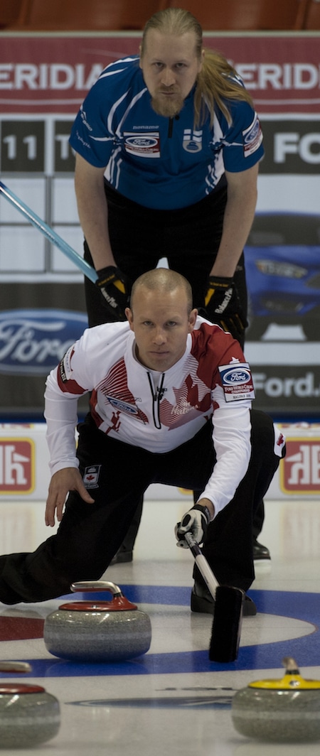  Pat Simmons du Canada vérifie un coup avec Aku Kauste de la Finlande regardant par-dessus son épaule. (Photo, Curling Canada / Michael Burns)