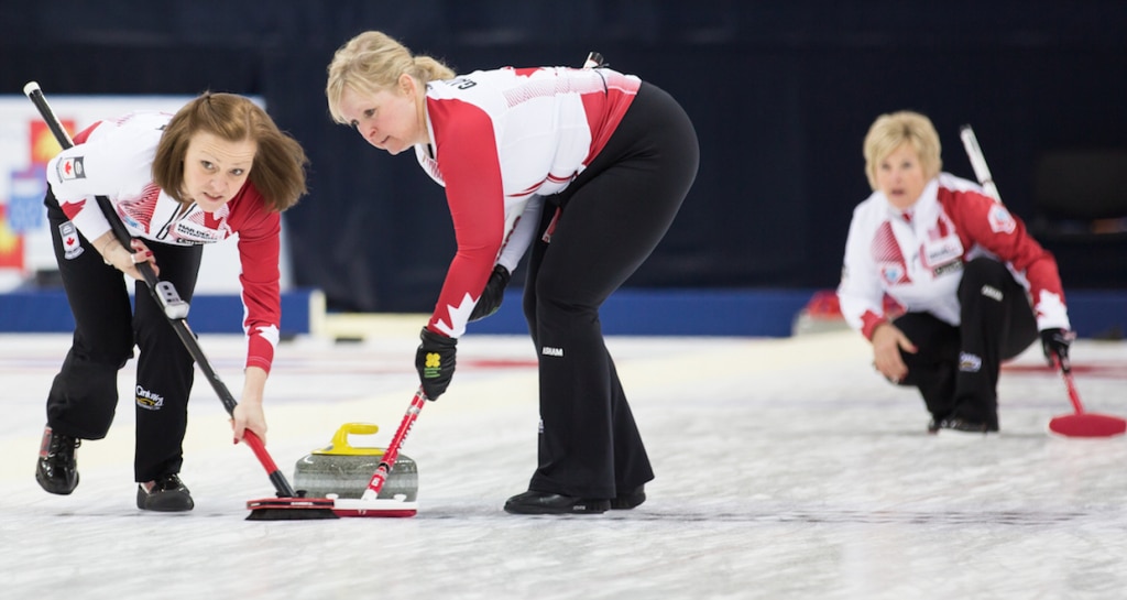 Allyson Steward and Cathy Gauthier sweep Lois Fowler's rock during action at the 2015 World Senior Curling Championships in Sochi, Russia (WCF/Céline Stucki Photo)
