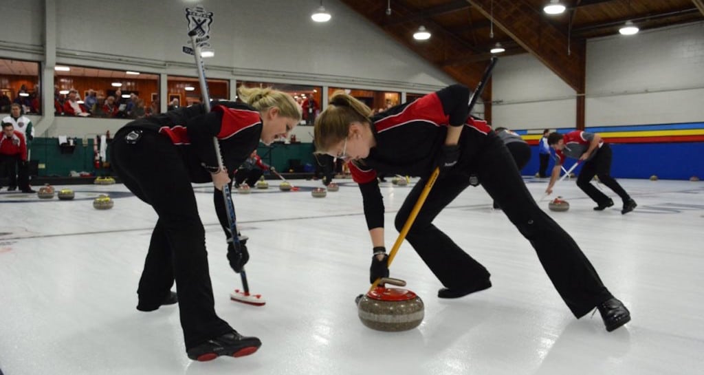 Marie Christianson et Lauren Wasylkiw (Terre-Neuve) se mettent au travail avec les brosses durant le Championnat canadien 2016 de curling mixte à Toronto (Photo de Curling Canada/Sonja DiMarco)