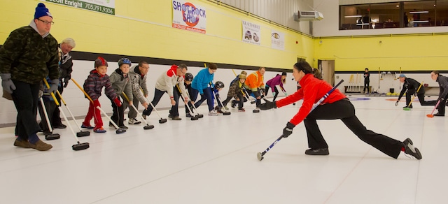 Instructor Abbie Darnley demonstrates delivery techniques to participants in the Curling Canada Rocks & Rings session at the Stroud Curling Club (Photo Ramsey Blacklock/Rock Solid Productions)