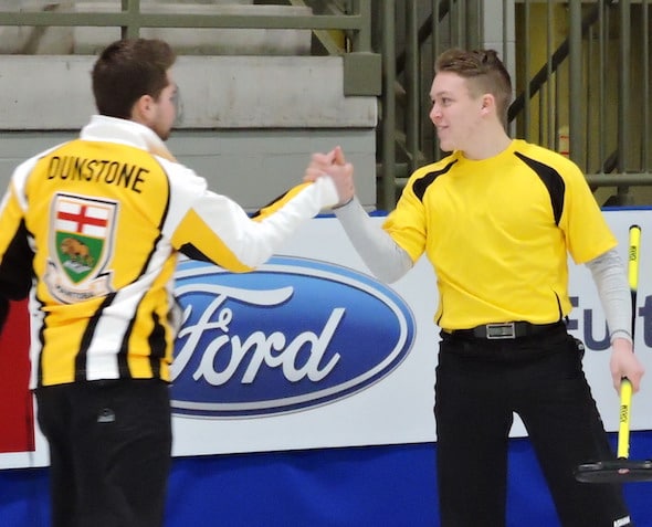 Manitoba lead Rob Gordon, right, congratulates skip Matt Dunstone during Monday's win over Alberta. (Photo, Curling Canada)