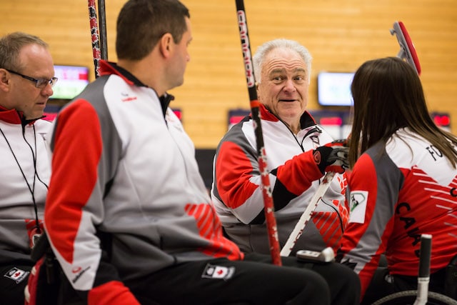 Skip Jim Armstrong and teammates (l-r) Dennis Thiessen, Mark Ideson and Ina Forrest confer during their game at the 2016 World Curling Championship in Lucerne, Switzerland (WCF/Céline Stucki photo)