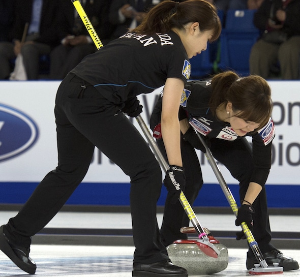 Yurika Yoshida du Japon, à gauche, et Chinami Yoshida balayent lors de leur victoire sur la Russie dimanche. (Photo, Curling Canada / Michael Burns)