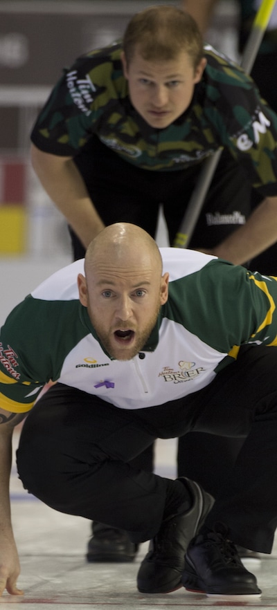 Ottawa Ont.Mar 7, 2016.Tim Hortons Brier, Northern Ontario third Ryan Fry checks the stones line after delivering his stone as Team Canada second Carter Rycroft checks the path over his shoulder during draw 7 at the Brier. michael burns photo