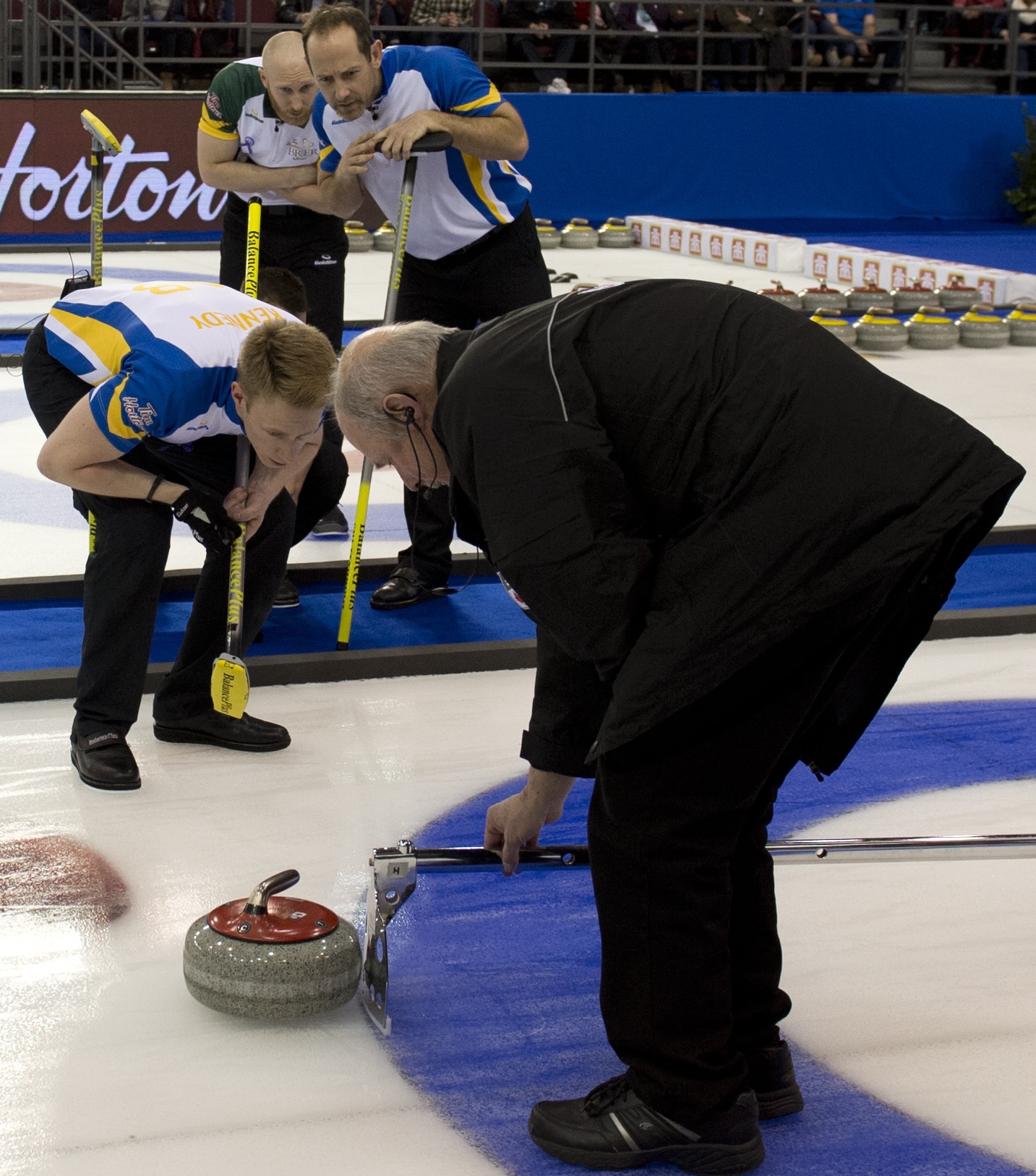 Troisième Alberta Marc Kennedy, à gauche, regarde attentivement la mesure 10-end menée par jeu arbitre Irénée Gaudreau. (Photo, Curling Canada / Michael Burns)