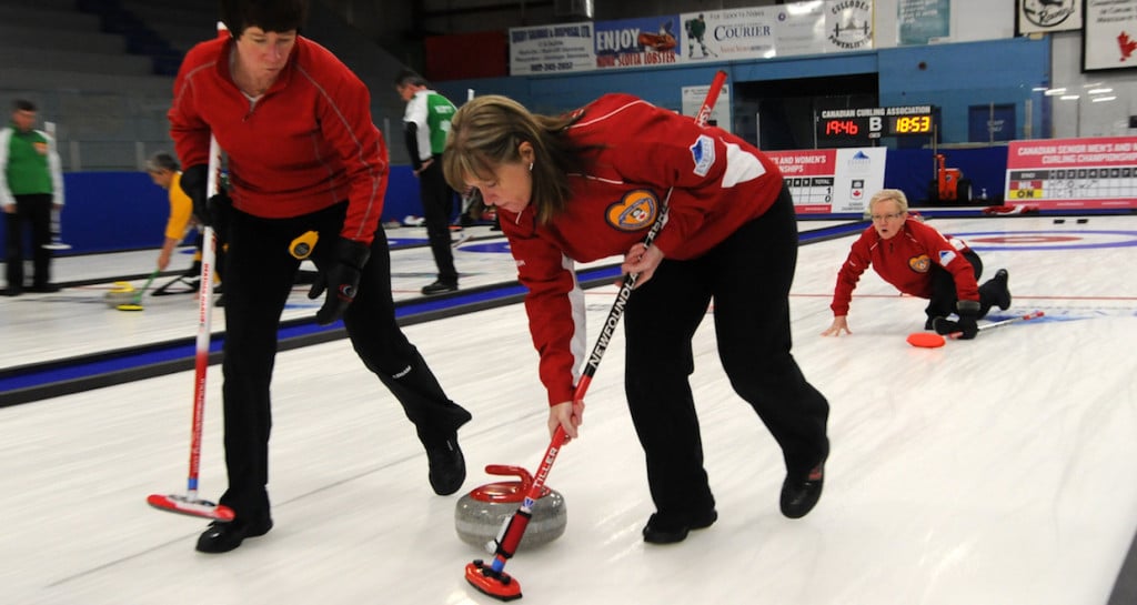Newfoundland and Labrador skip Cathy Cunningham watches her rock as sweepers Heather Martin and Patricia Tiller take over at the 2016 Canadian Seniors Championship (Curling Canada/Mike Lewis photo)