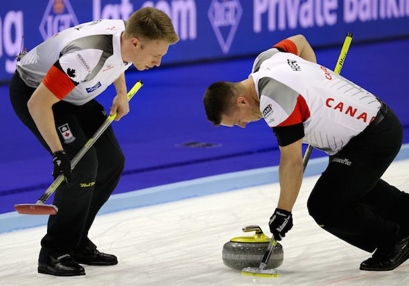 Team Canada's Ben Hebert, right, puts his back into it, with Marc Kennedy offering encouragement. (Photo, World Curling Federation/Richard Gray)