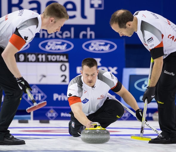 Team Canada lead Ben Hebert delivers rock to sweepers Marc Kennedy, left, and Brent Laing. (Photo, World Curling Federation/Céline Stuckli)