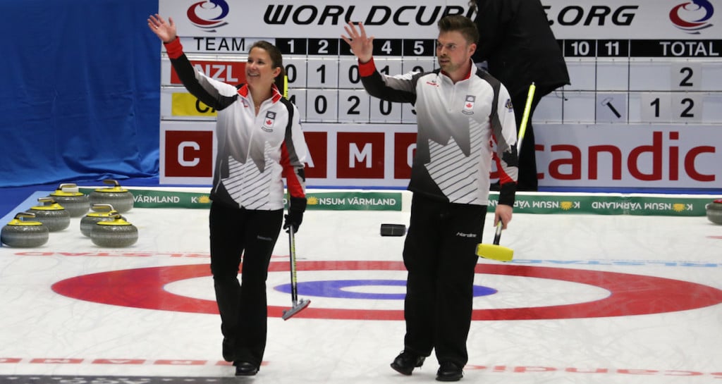 Marliese Kasner and Dustin Kalthoff wave to Canadian fans after a win during the round robin of the 2016 World Mixed Doubles Curling Championship in Karlstad, Sweden (WCF/Richard Gray photo)