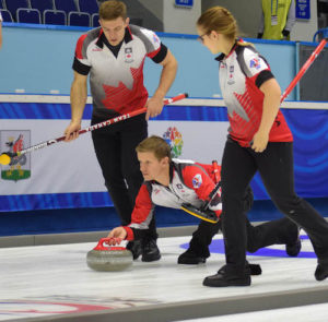 Team Canada skip Mick Lizmore delivers his rock, closely watched by second Brad Thiessen and lead Alison Kotylak during action at the Kazan Sport Palace during the 2016 World Mixed Curling Championship (Photo World Curling Federation/Alina Androsova)