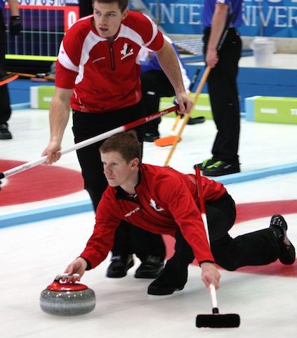 Team Canada third Michael Lizmore slides out as second Brad Thiessen prepares to sweep during Sunday morning action at the 2013 Winter Universiade in Trentino, Italy (Photo courtesy L. Thiessen)