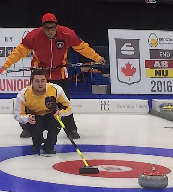 Nunavut skip Arthur Siksik peers over the shoulder of Manitoba skip Matt Dunstone during Draw 1 action on Saturday.