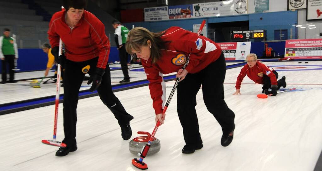 Newfoundland and Labrador skip Cathy Cunningham watches her rock as sweepers Heather Martin and Patricia Tiller take over at the 2016 Canadian Seniors Championship (Curling Canada/Mike Lewis photo)