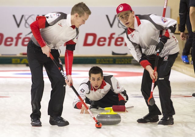 Team Canada third Colton Lott delivers his rock with sweepers Robbie Gordon and Kyle Doering watching closely (WCF/Marissa Tiel photo)